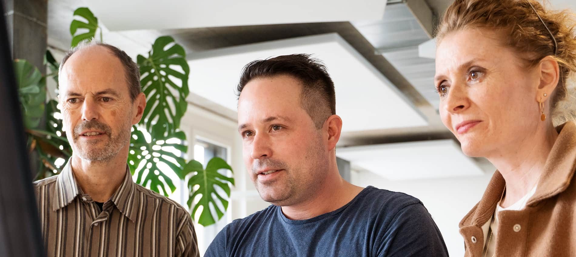 Mike Weibel, Sämi Hauser und Jennifer Singer besprechen ein Kundenprojekt am Bildschirm.